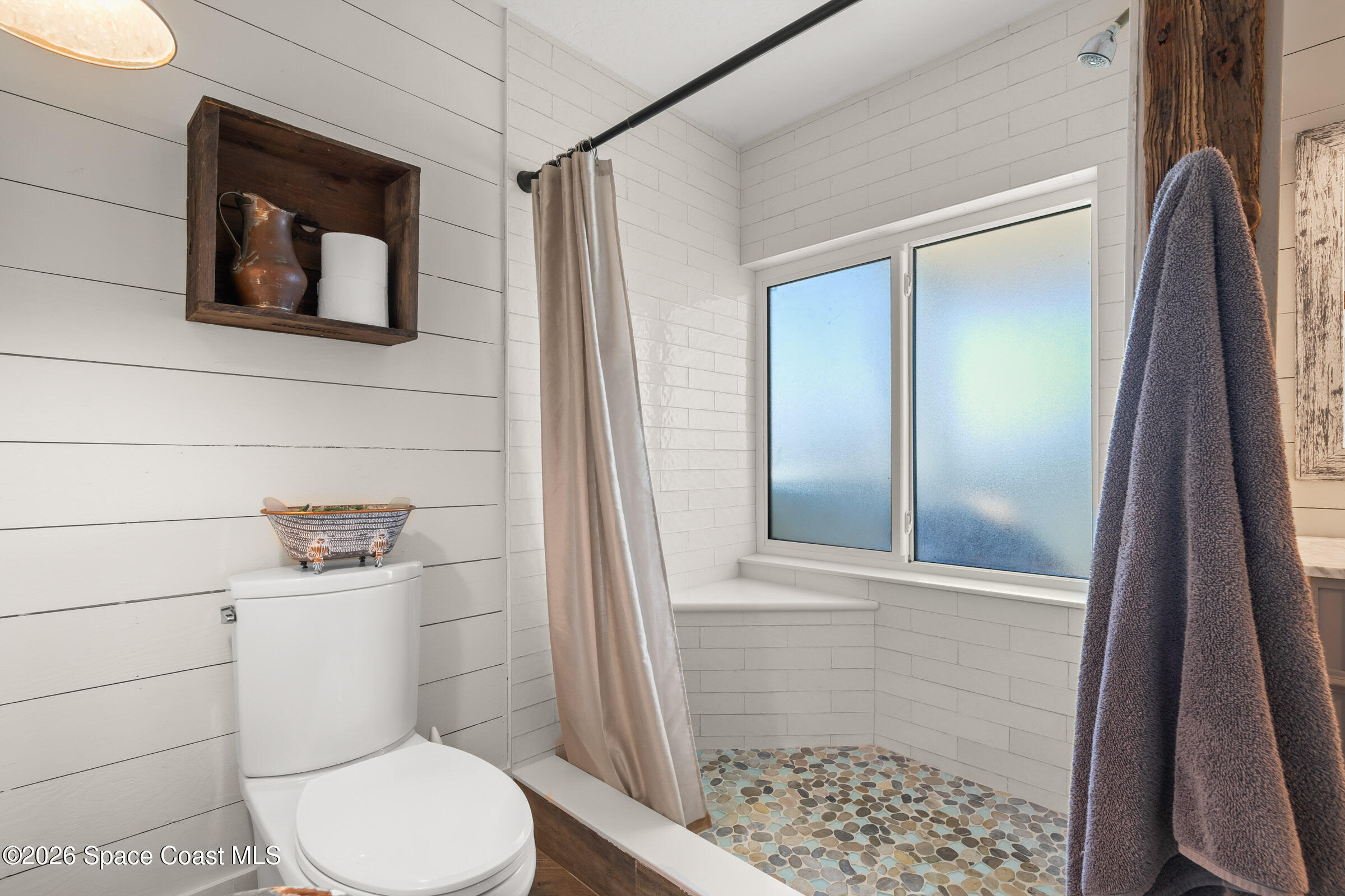 700 Wave Crest Avenue, Unit 206 Indialantic, FL 32903 - Photo 24 of 36 a bathroom with a toilet and a shower