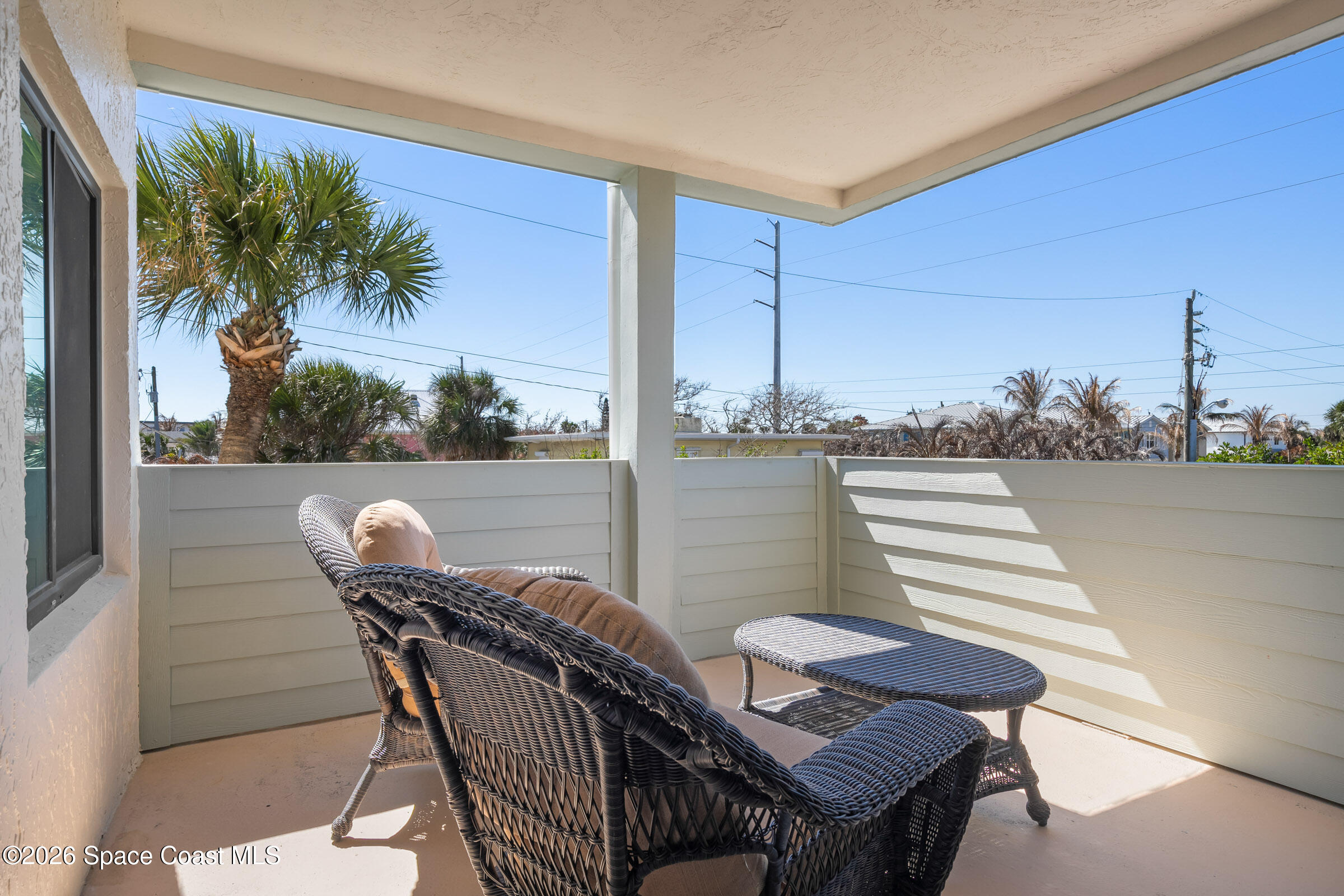 700 Wave Crest Avenue, Unit 206 Indialantic, FL 32903 - Photo 31 of 36 a view of a balcony with table and chairs and potted plants