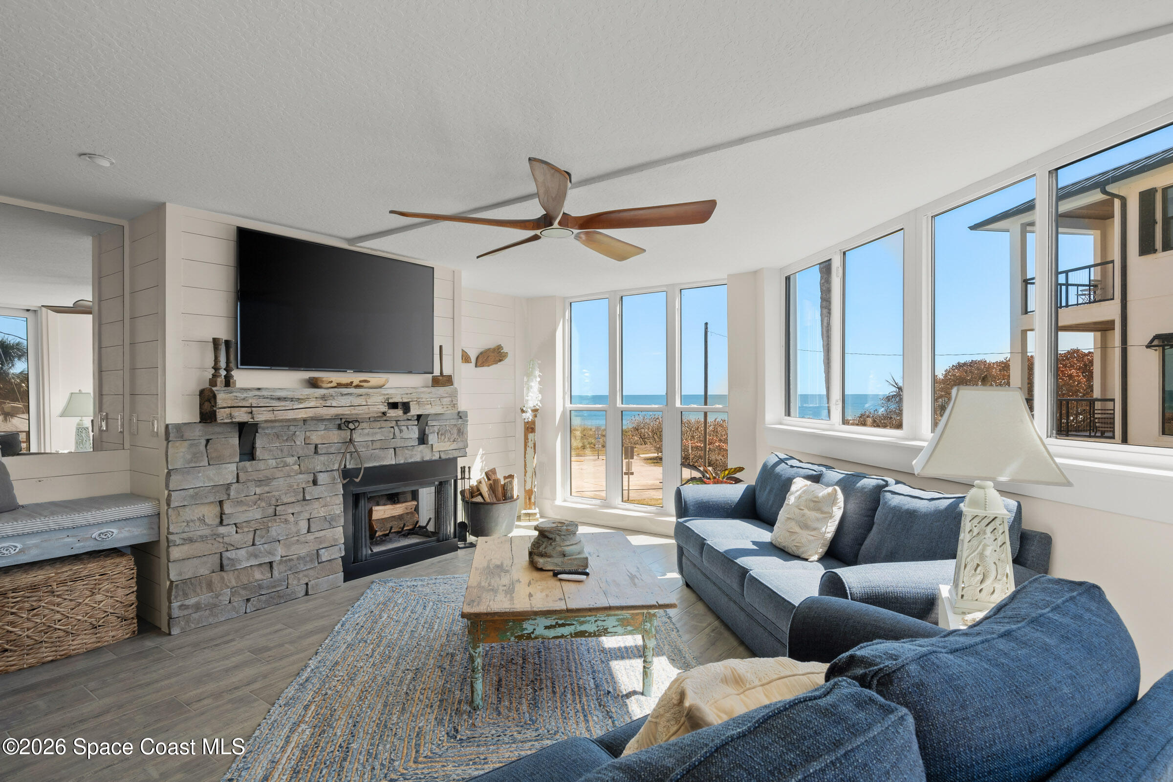 700 Wave Crest Avenue, Unit 206 Indialantic, FL 32903 - Photo 4 of 36 a living room with fireplace furniture and a flat screen tv