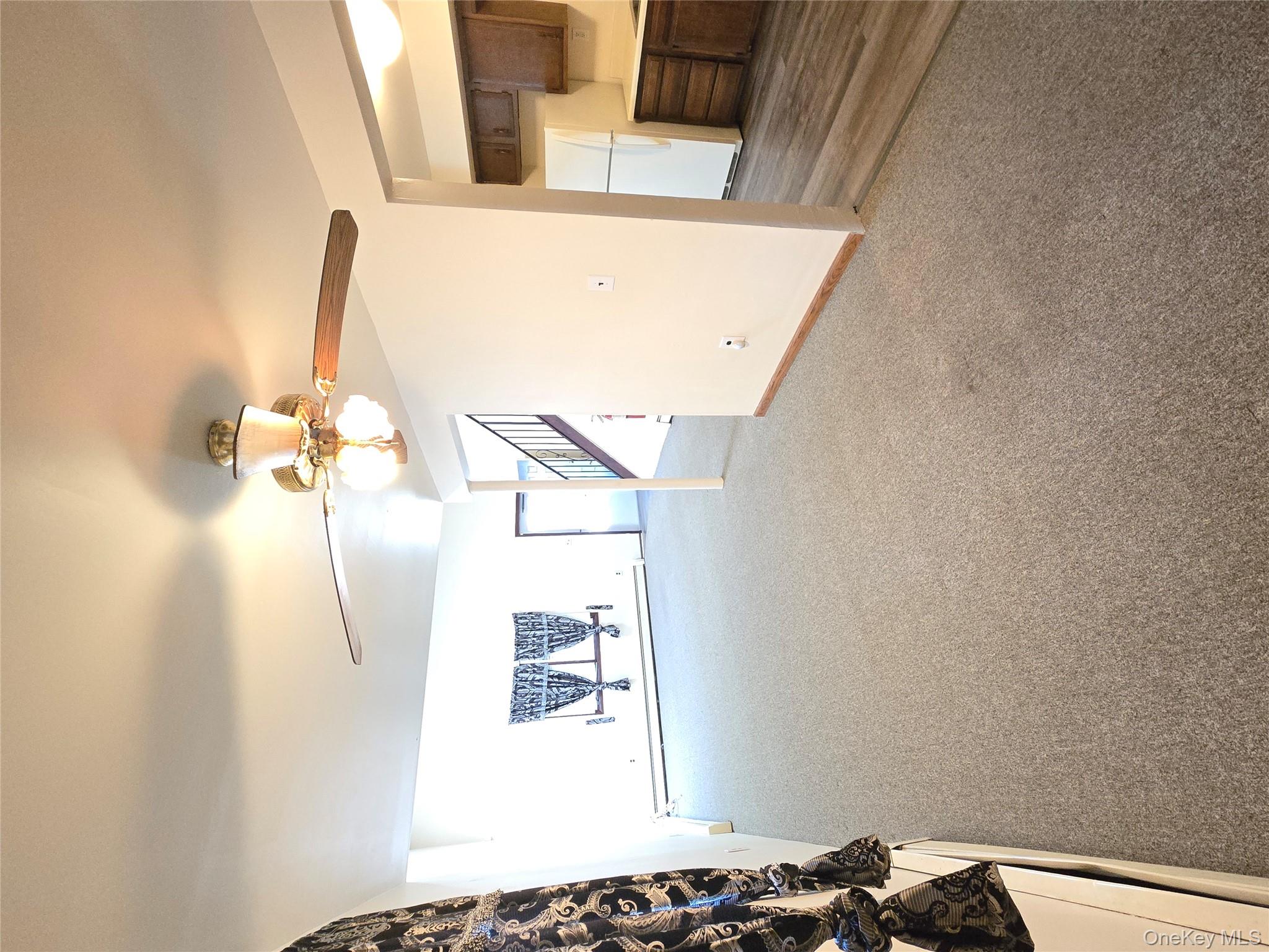 32 Genung Street, Unit 2 Middletown, NY 10940 - Photo 3 of 9 Unfurnished living room with light colored carpet, ceiling fan, and a baseboard heating unit