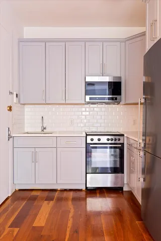 a kitchen with granite countertop white cabinets stainless steel appliances and sink