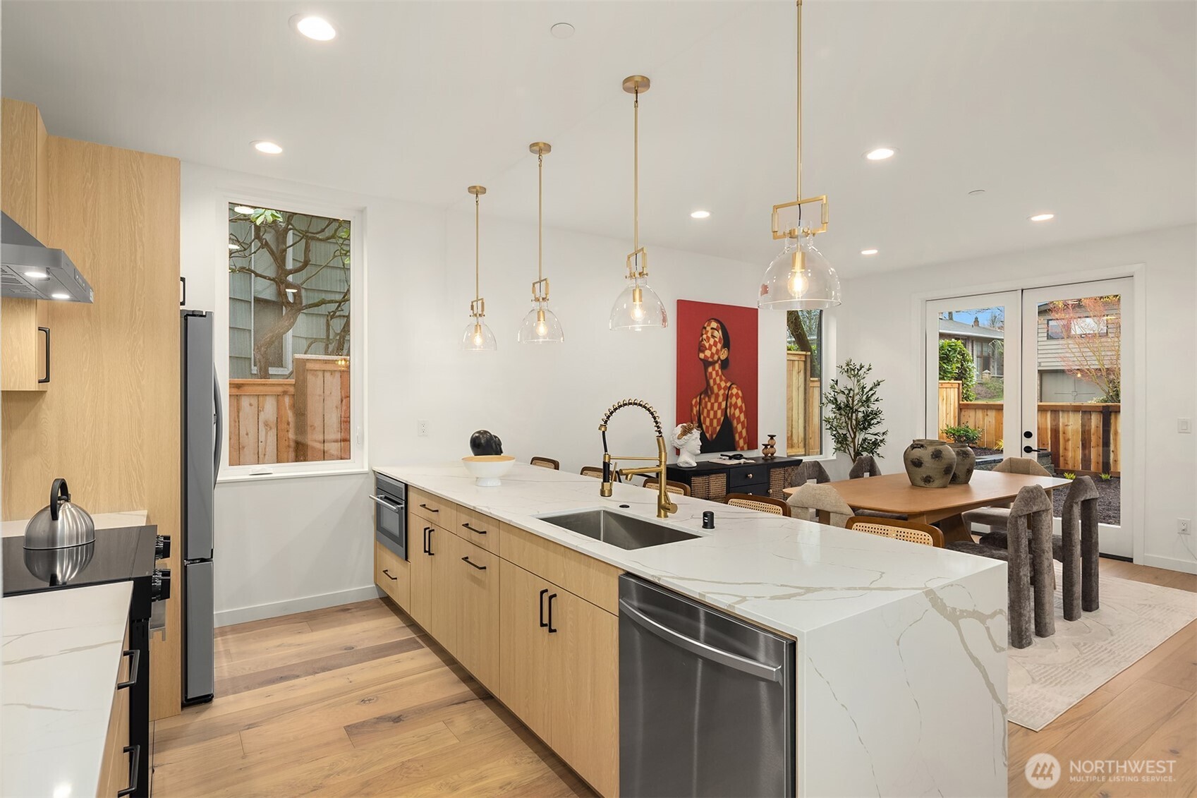 2340 North 64th Street, Unit A Seattle, WA 98103 - Photo 8 of 29 a kitchen with stainless steel appliances kitchen island a sink a stove and chairs