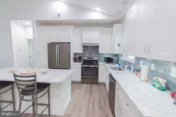 a kitchen with stainless steel appliances a sink dishwasher a stove microwave and cabinets