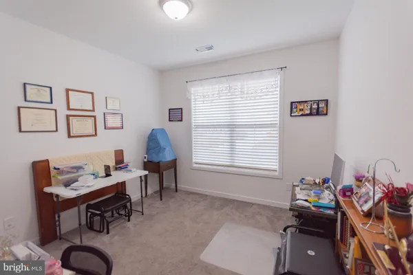 a view of a workspace with furniture and a window
