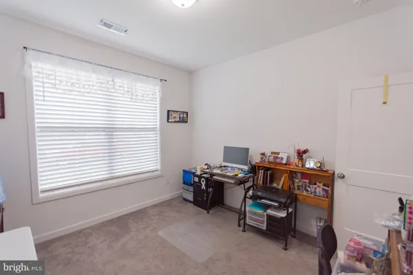 a view of a workspace with furniture and a window