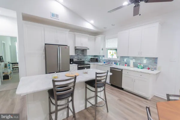 a kitchen with a refrigerator a stove a dining table and chairs