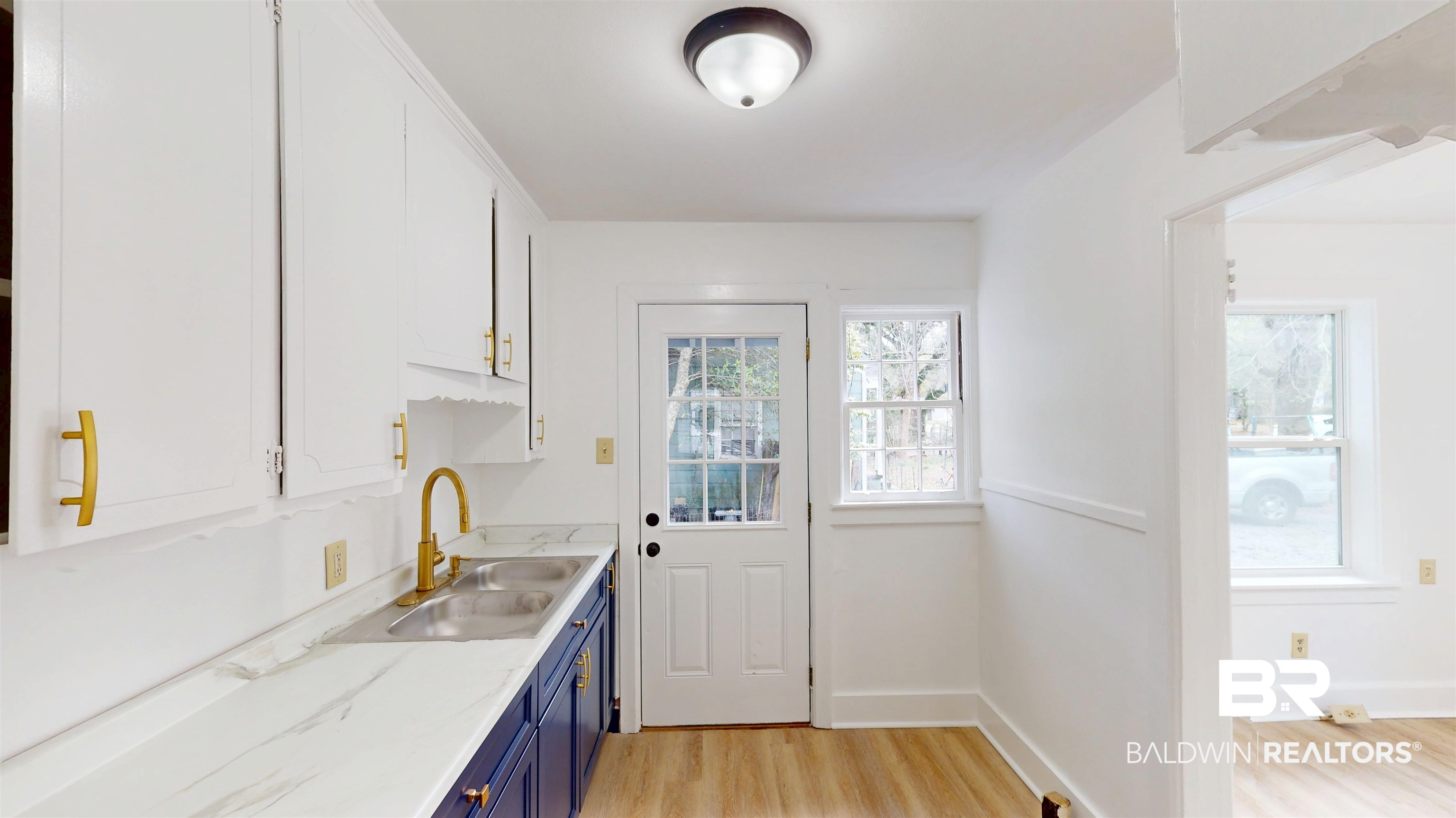 606 Shady Oak Drive Mobile, AL 36608 - Photo 7 of 14 Two tone kitchen with light countertops, two tone color scheme, and light wood-style floors