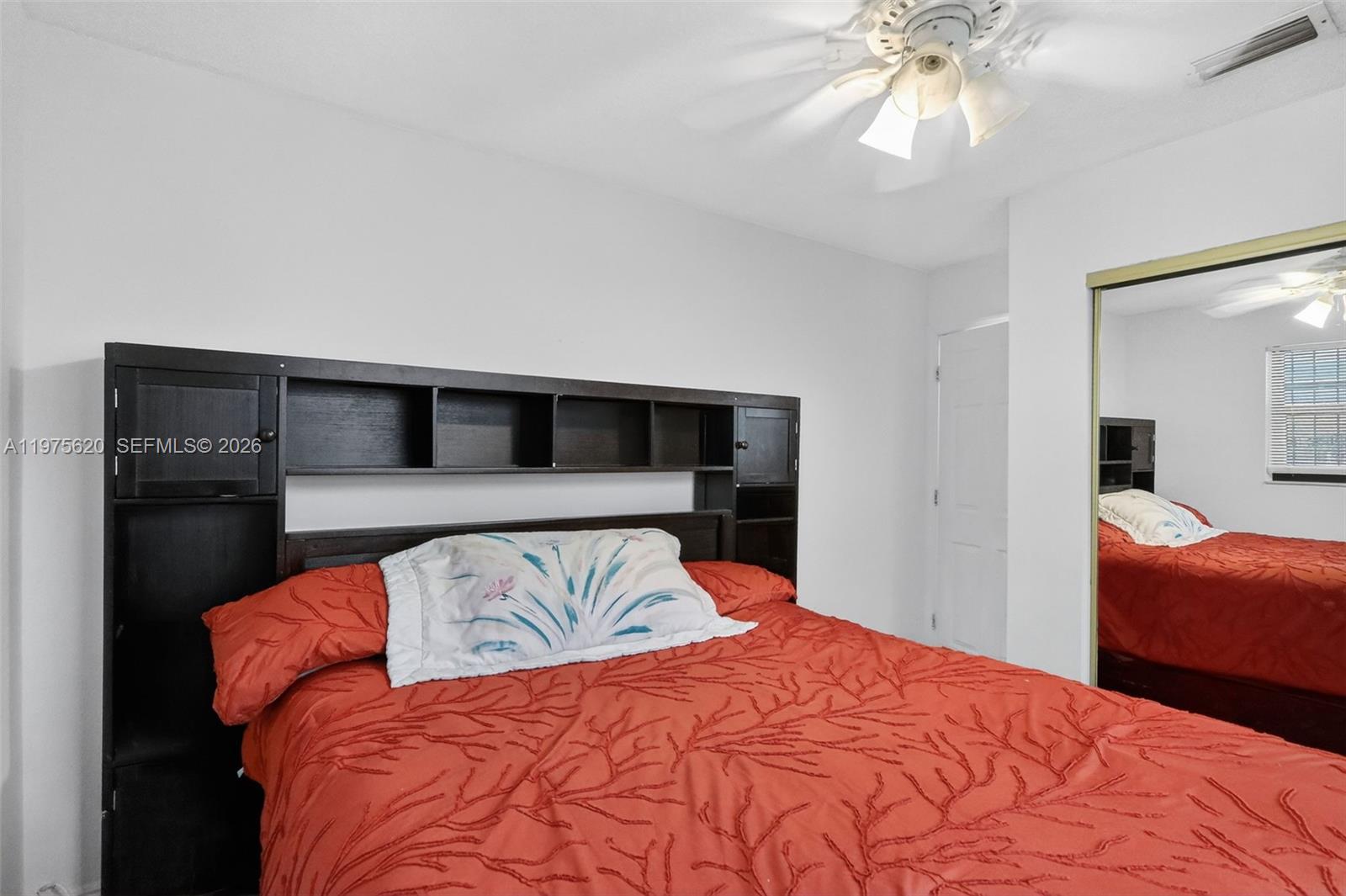 834 Northwest 115th Street Miami, FL 33168 - Photo 18 of 46 a bedroom with a large bed and a chandelier