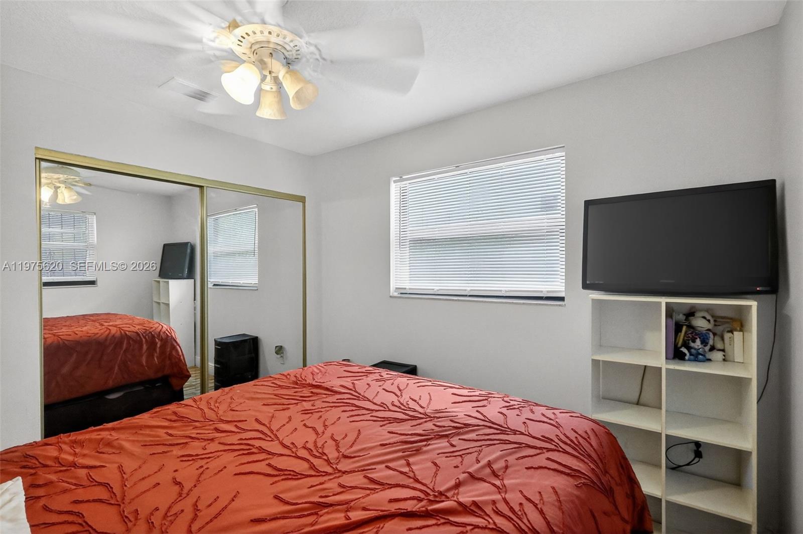 834 Northwest 115th Street Miami, FL 33168 - Photo 19 of 46 a bedroom with a bed and a flat screen tv
