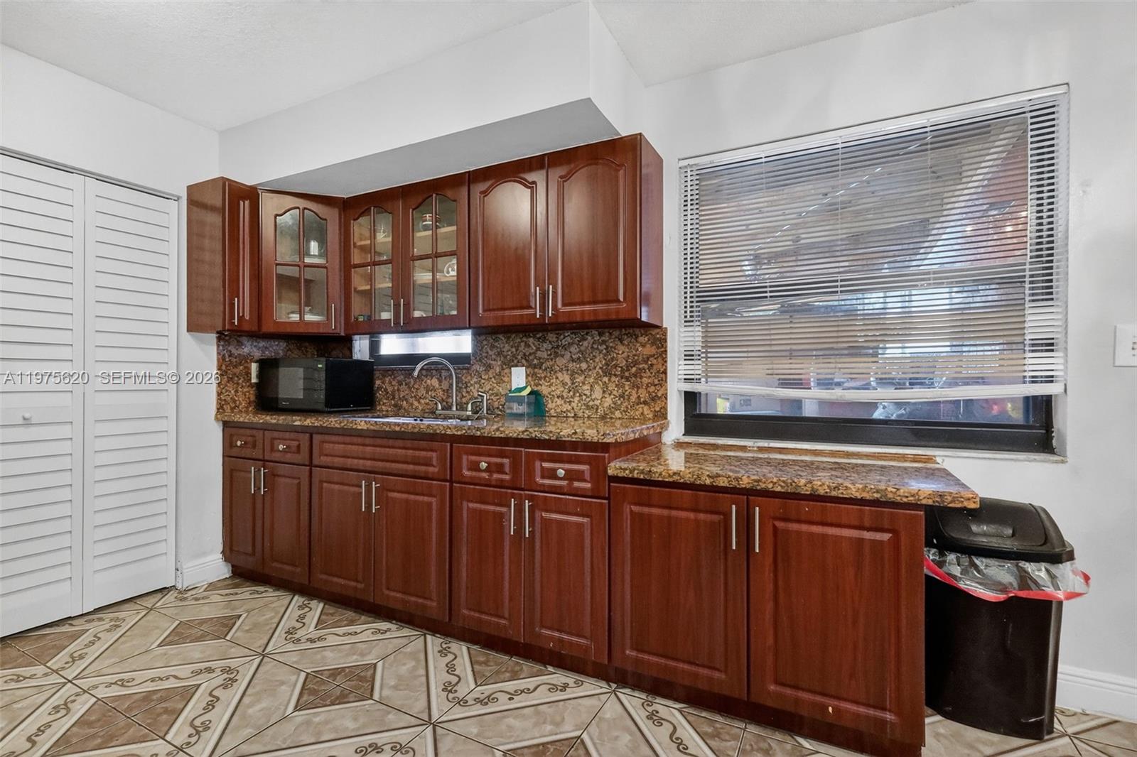 834 Northwest 115th Street Miami, FL 33168 - Photo 23 of 46 a kitchen with granite countertop wooden cabinets and a stove top oven