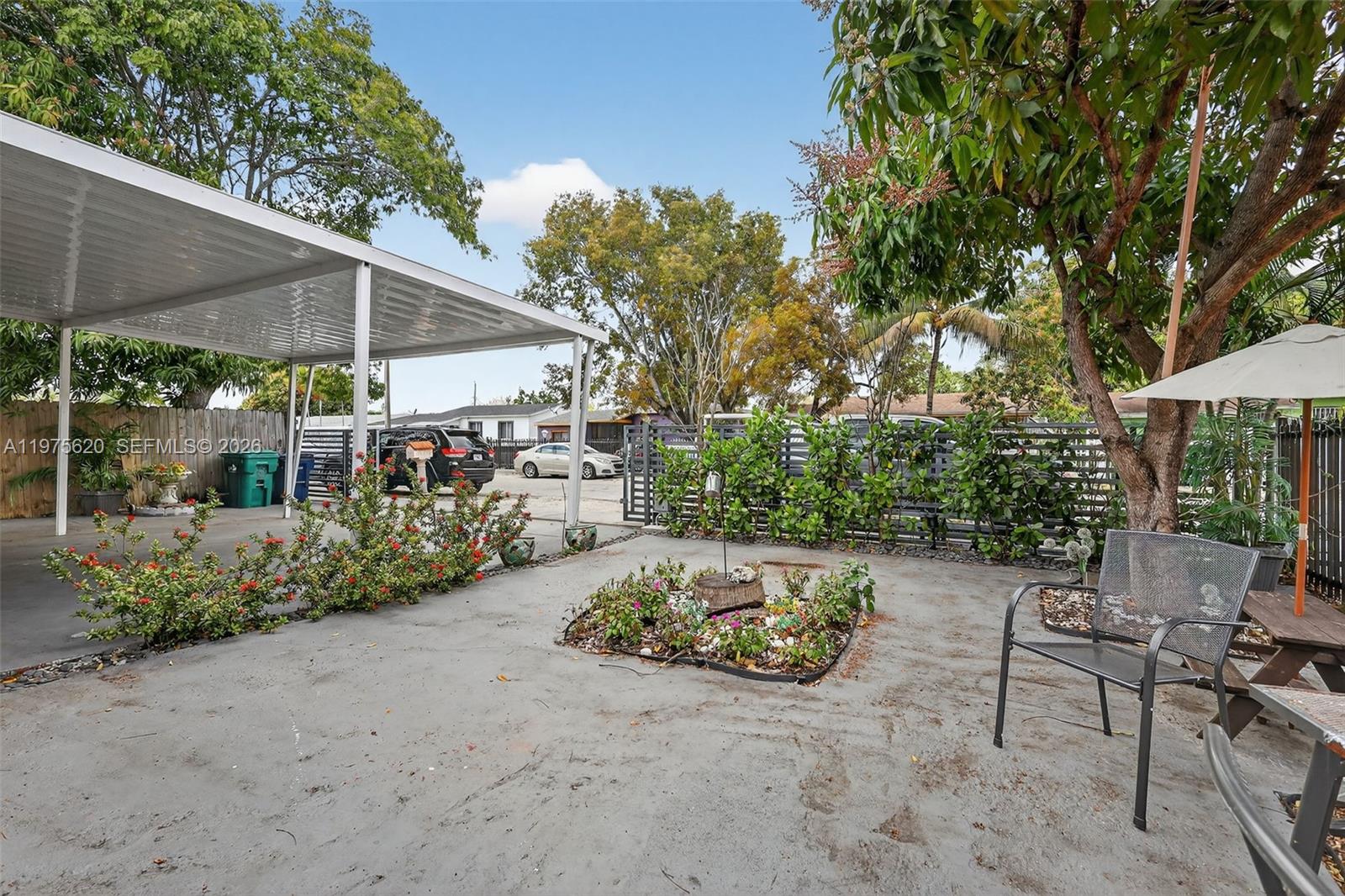 834 Northwest 115th Street Miami, FL 33168 - Photo 6 of 46 a view of a patio with table and chairs under an umbrella