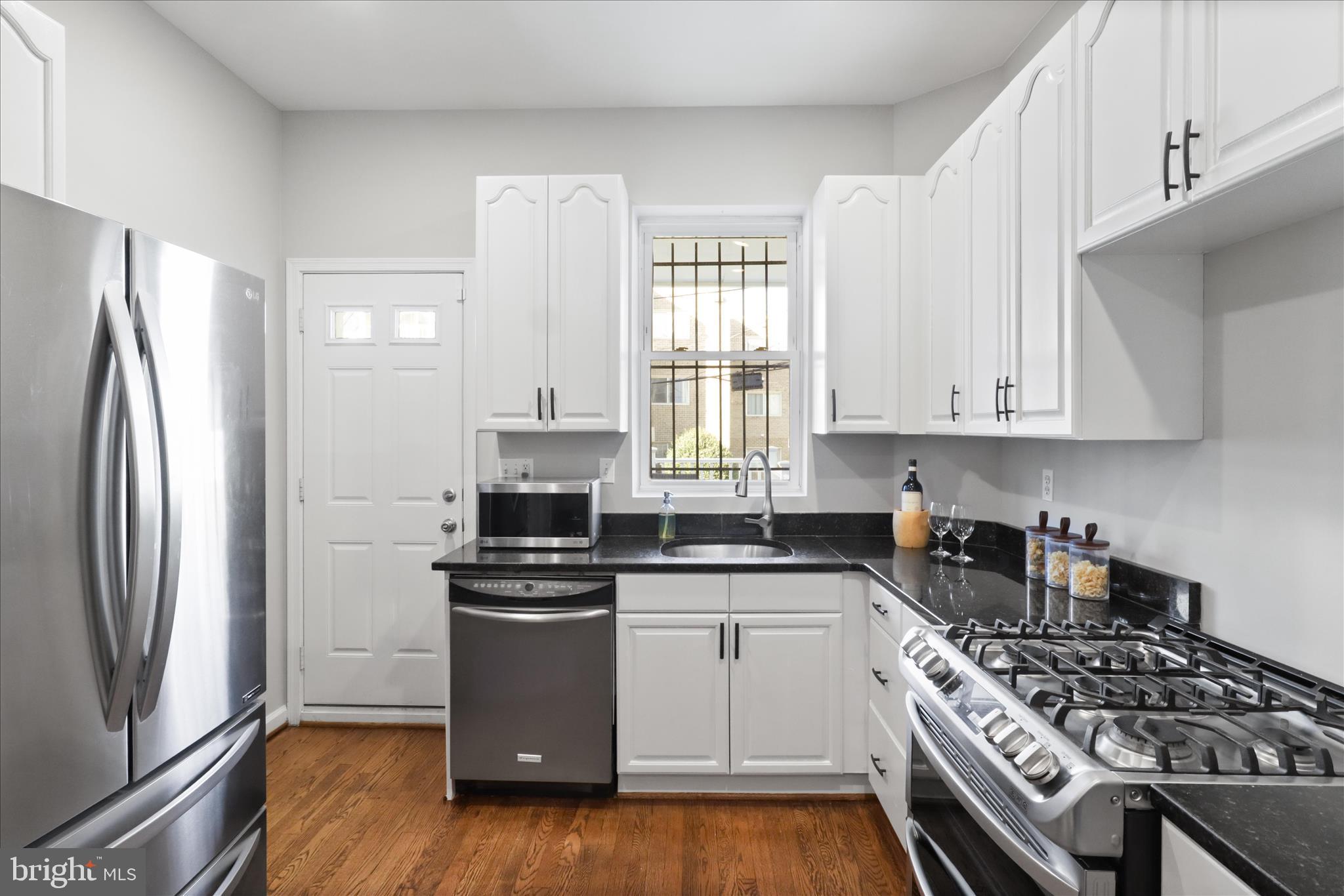 1327 Harvard Street Northwest Washington, DC 20009 - Photo 15 of 61 a kitchen with stainless steel appliances a sink a stove a refrigerator and cabinets