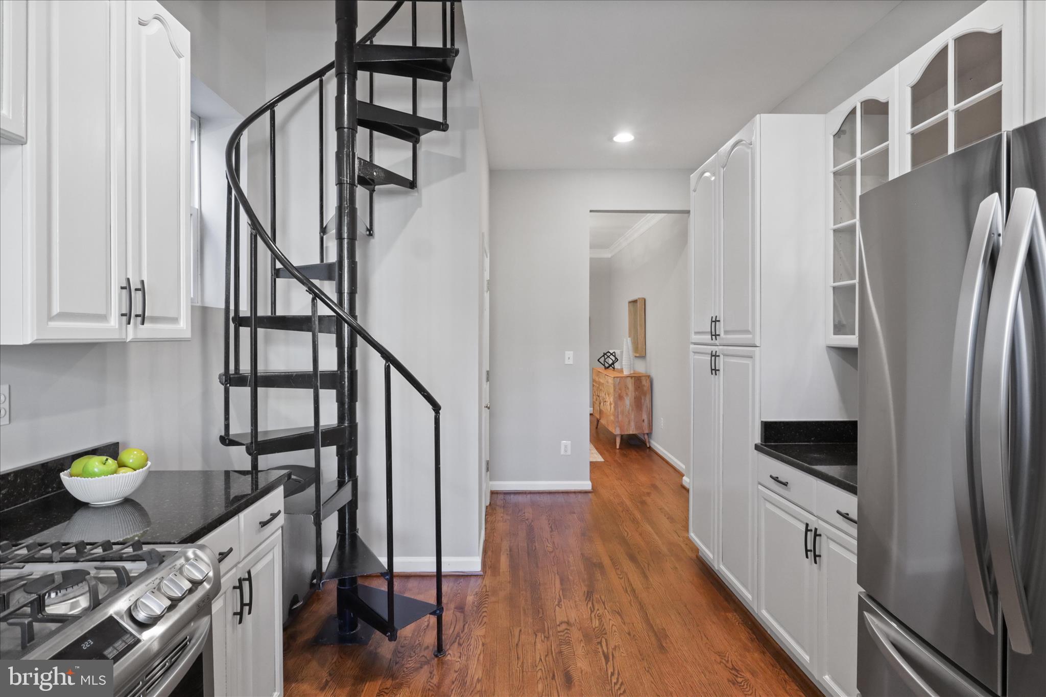 1327 Harvard Street Northwest Washington, DC 20009 - Photo 17 of 61 a kitchen with stainless steel appliances granite countertop a stove a refrigerator and a wooden floor