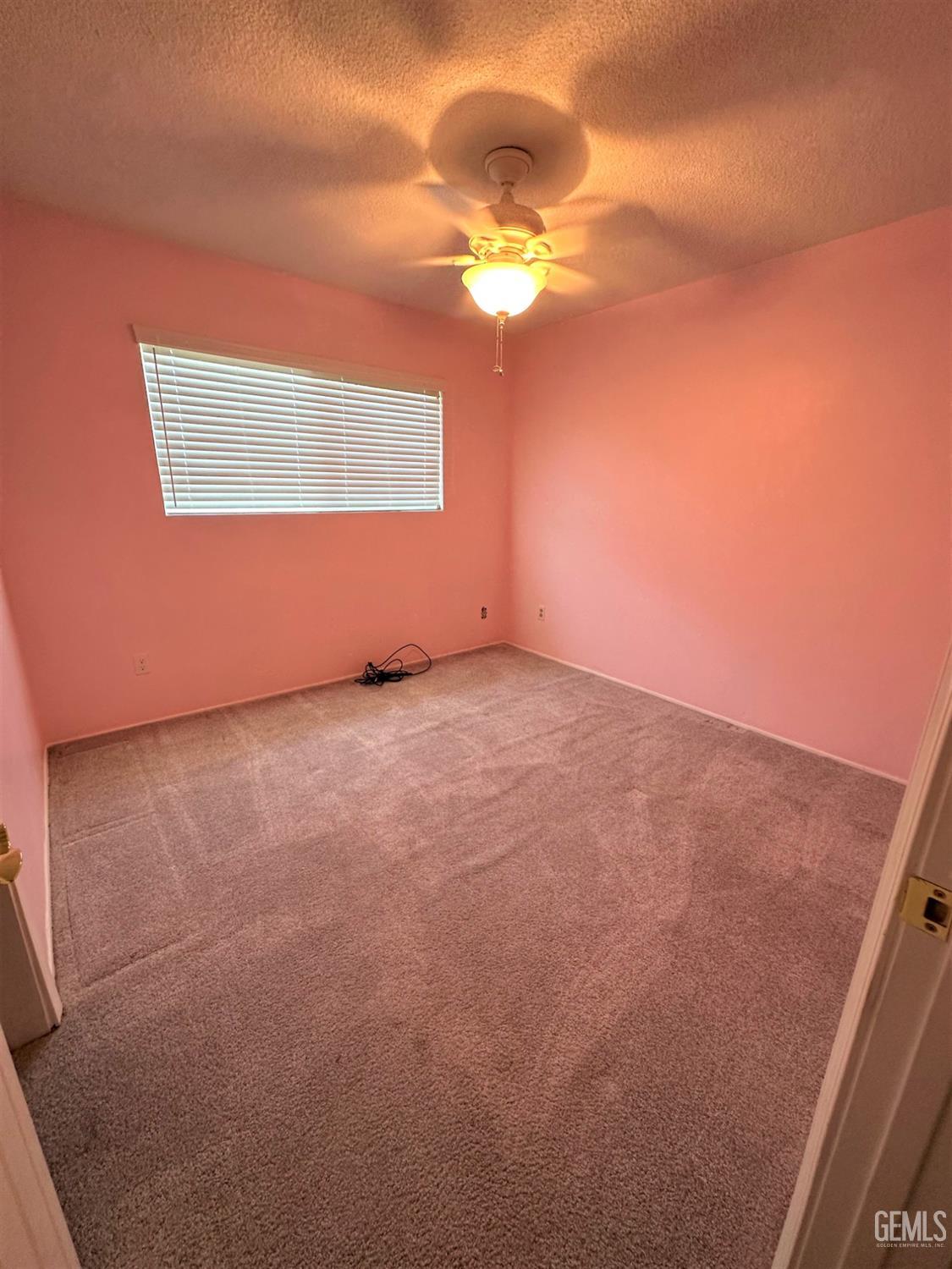 Undisclosed Address Bakersfield, CA 93306 - Photo 17 of 24 an empty room with a chandelier fan and windows