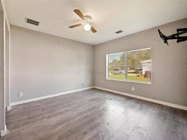 wooden floor in an empty room with a window