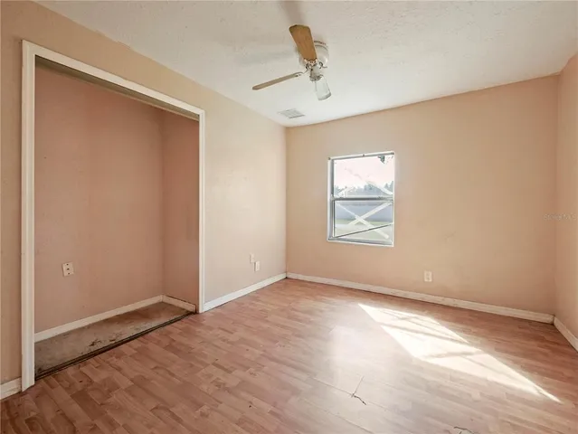 an empty room with windows and closet