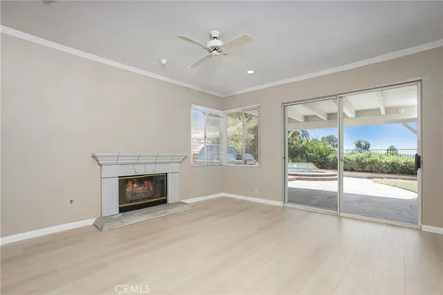 an empty room with fireplace fan and windows