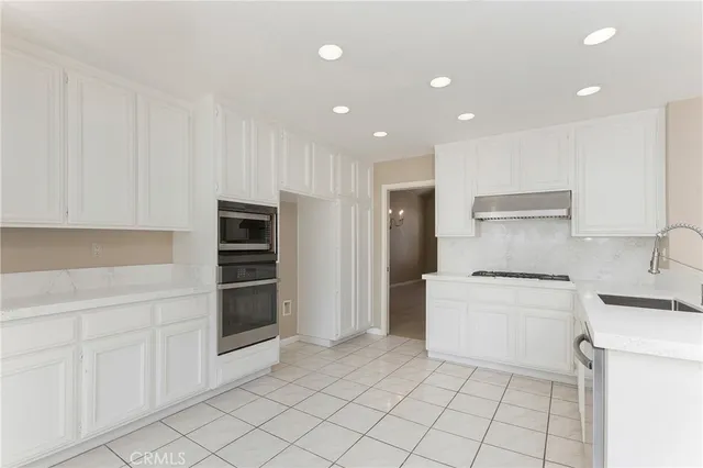 a kitchen with a sink a stove and cabinets