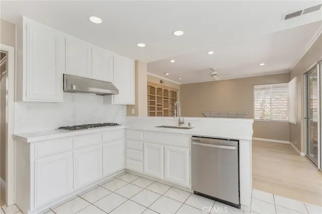 a kitchen with white cabinets appliances and a sink