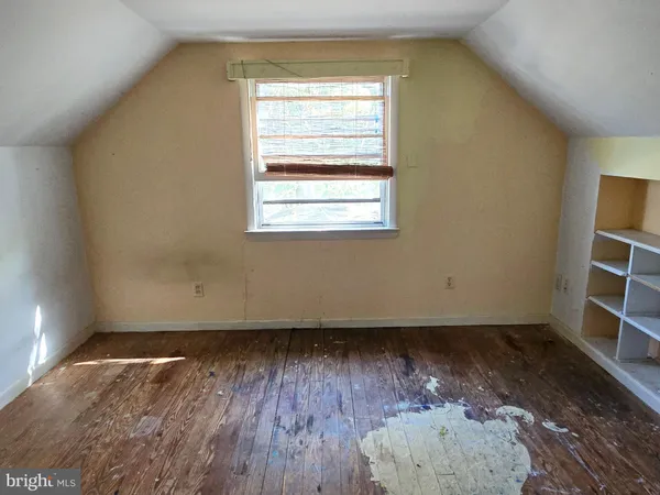 an empty room with wooden floor and window