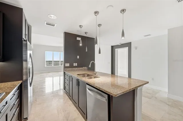 a kitchen with stainless steel appliances granite countertop a sink a stove and refrigerator