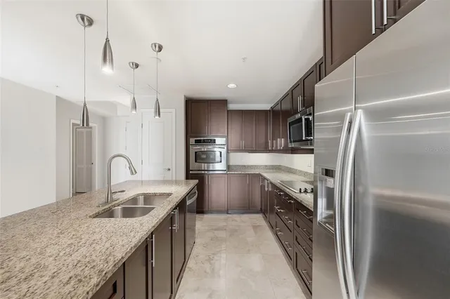 a kitchen with stainless steel appliances granite countertop a stove a sink and a refrigerator