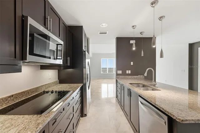 a view of a kitchen with stainless steel appliances granite countertop a stove and a sink
