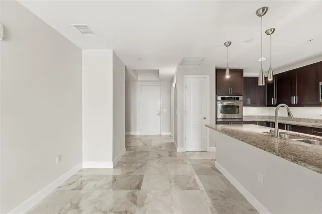 a kitchen with stainless steel appliances granite countertop a stove microwave and sink