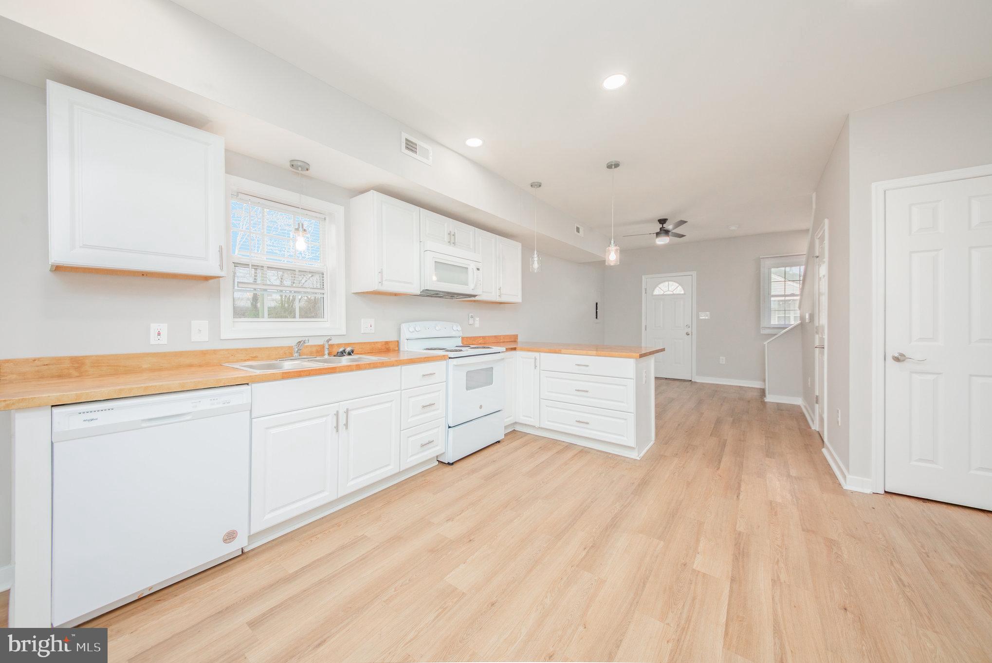 a open kitchen with kitchen island white cabinets and sink