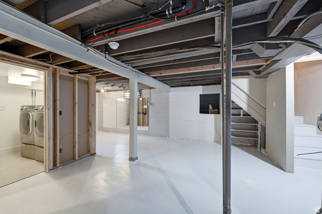 1925 South Main Street Bountiful, UT 84010 - Photo 22 of 48 Unfinished basement space featuring exposed ceiling joists, white painted concrete flooring, and a laundry area with tile flooring