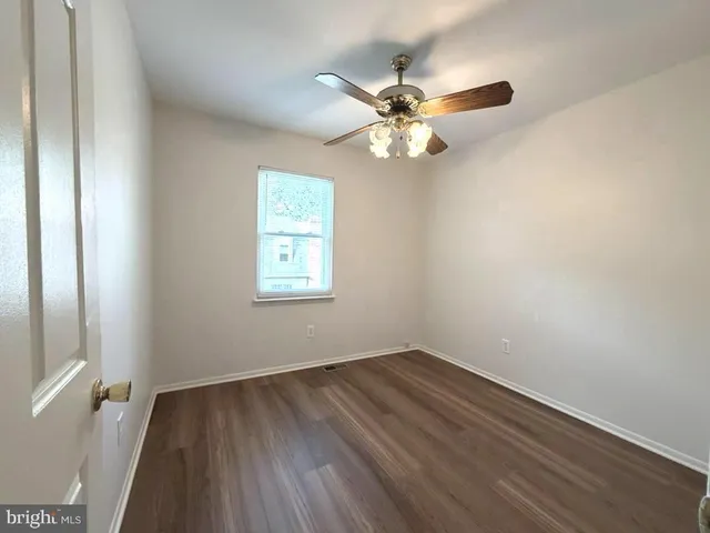 a view of a room with wooden floor and fan