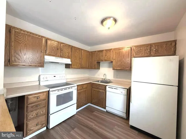 a kitchen with granite countertop stainless steel appliances a refrigerator a sink and cabinets