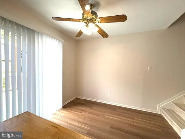 a view of a livingroom with a chandelier fan and wooden floor