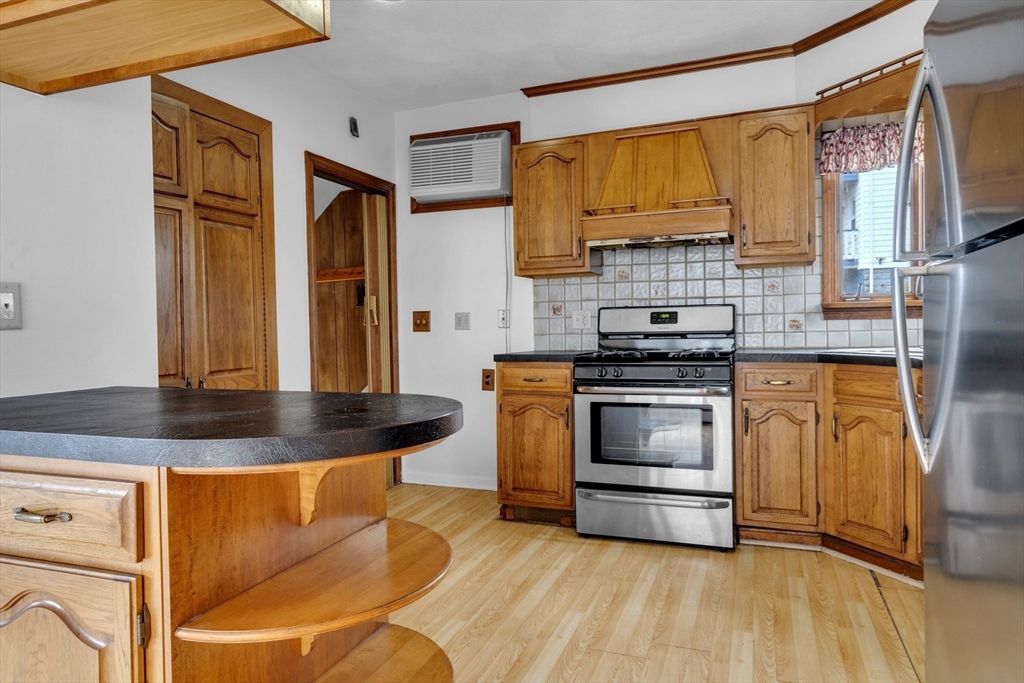 18 Butler Street Revere, MA 02151 - Photo 7 of 33 a kitchen with stainless steel appliances granite countertop a stove a sink and a microwave