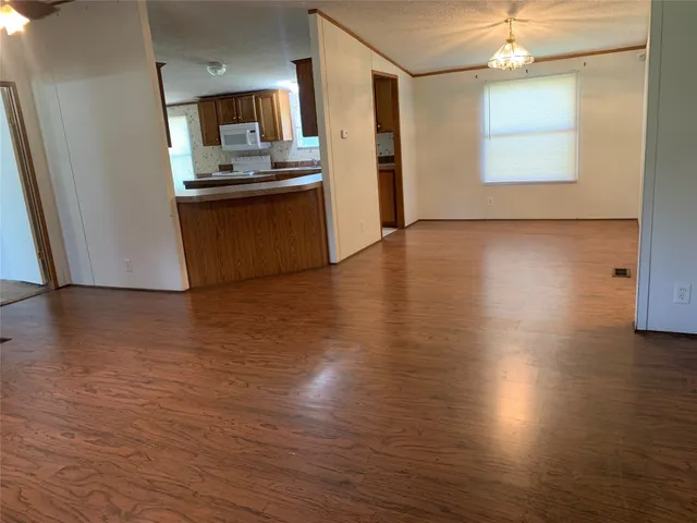 a kitchen with stainless steel appliances wooden floor and a refrigerator