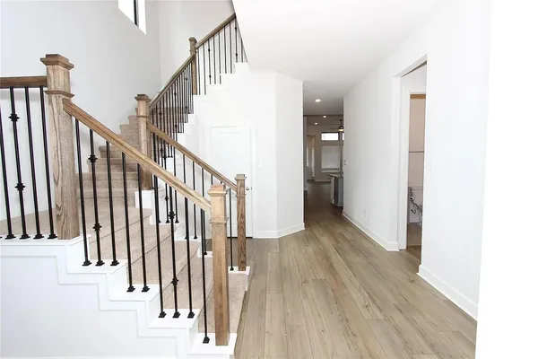 a view of hallway with stairs and wooden floor