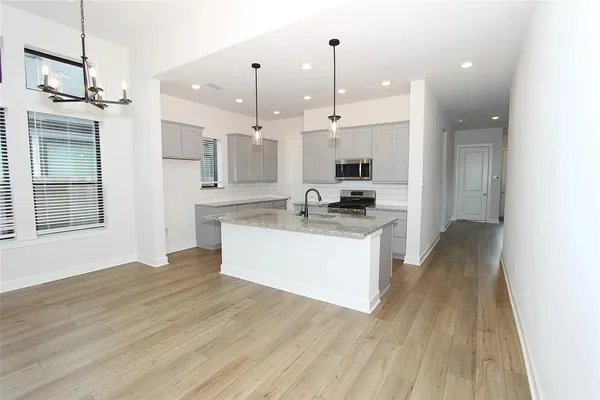 a large kitchen with kitchen island a sink stainless steel appliances and cabinets