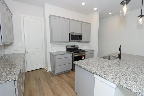a kitchen with a sink and a stove top oven