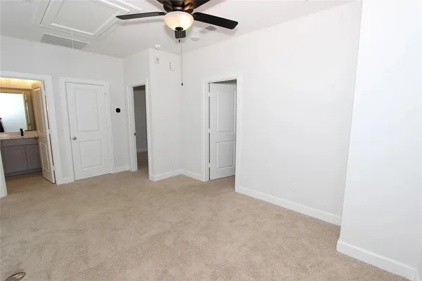 an empty room with a ceiling fan and a window