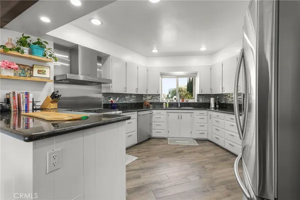 a kitchen with granite countertop cabinets stainless steel appliances and a sink