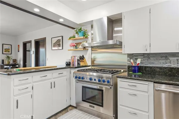 a kitchen with stainless steel appliances granite countertop a stove and a refrigerator