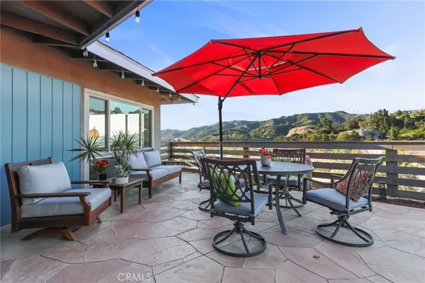 a view of a patio with a table and chairs under an umbrella