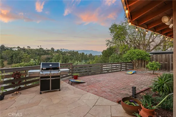 a view of a patio with table and chairs under an umbrella with a fire pit