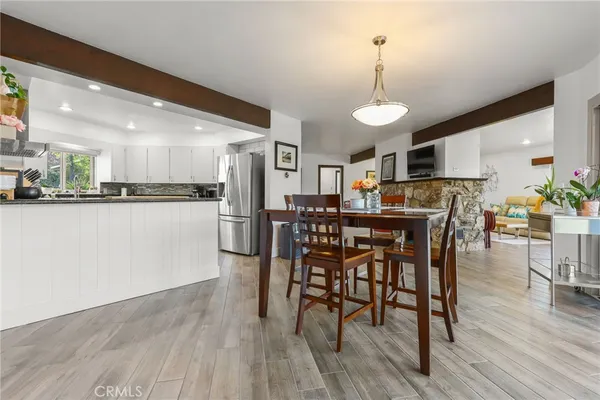 a view of a dining room and livingroom with furniture wooden floor a chandelier