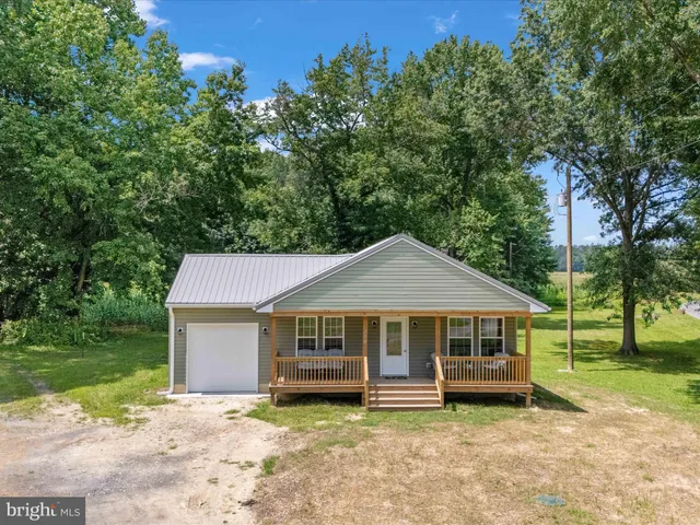 a wooden house with large trees in the background