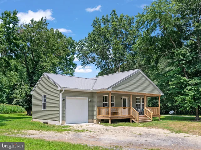 a front view of a house with a yard and trees