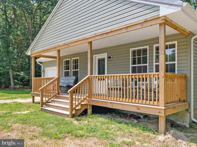 a view of a house with a yard and a wooden deck