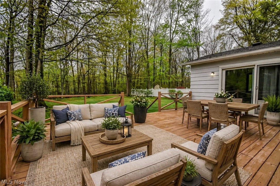 8242 Starburst Road Mentor, OH 44060 - Photo 3 of 37 Spacious wood-finish deck with multiple seating areas, a sliding glass door, and a horizontal plank exterior
