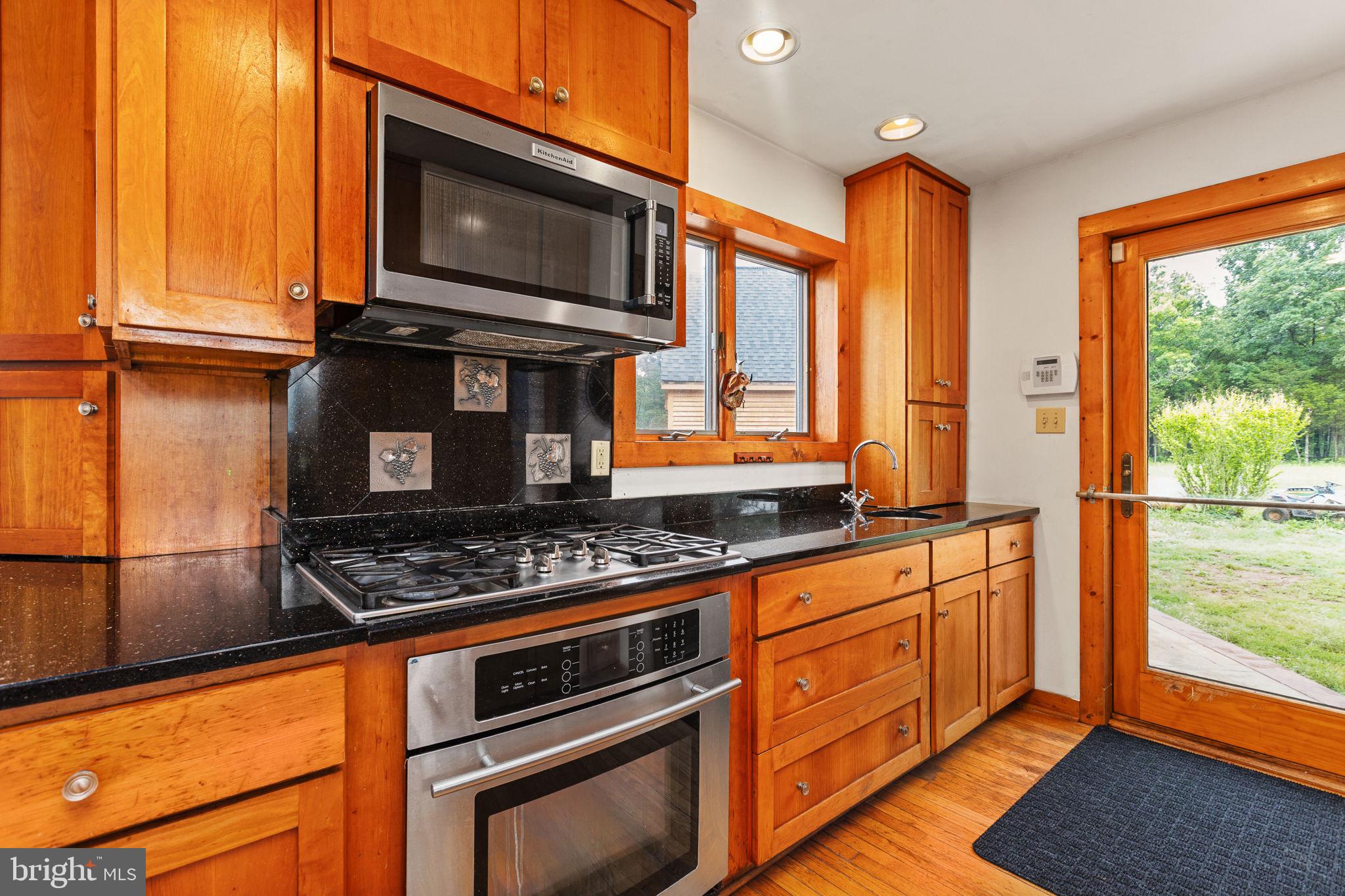6119 Beach Road Midland, VA 22728 - Photo 37 of 98 a kitchen with stainless steel appliances granite countertop a stove top oven microwave and cabinets