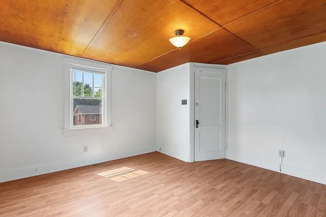 a view of a livingroom with wooden floor and window